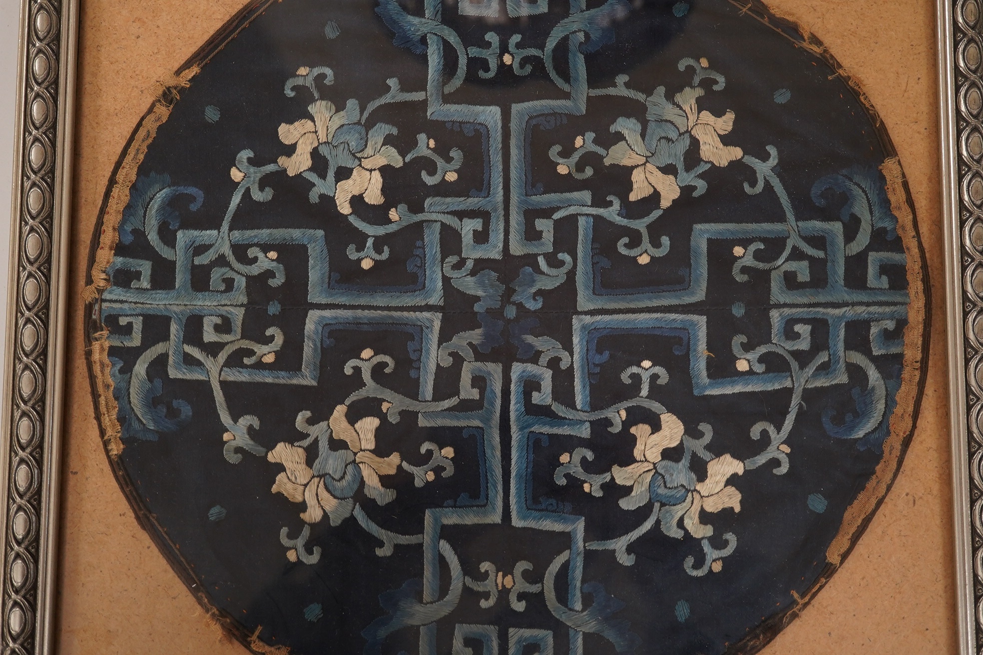 A framed 19th century Chinese silk embroidered floral roundel, possibly from a robe, 28cm diameter. Condition - main body of embroidery good, edging missing